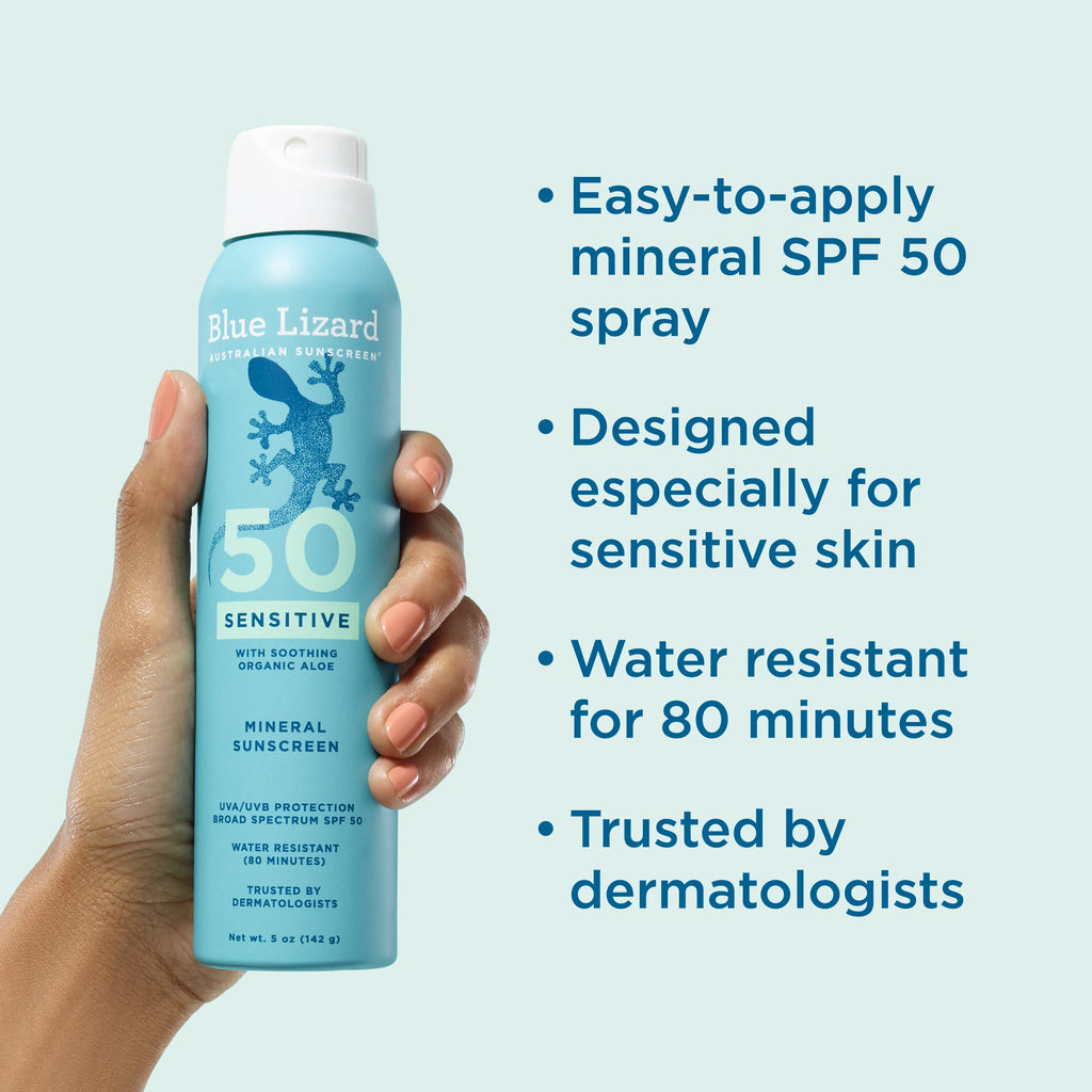 Hand holding a Blue Lizard sensitive mineral SPF 50 spray sunscreen with product features listed on a light blue background